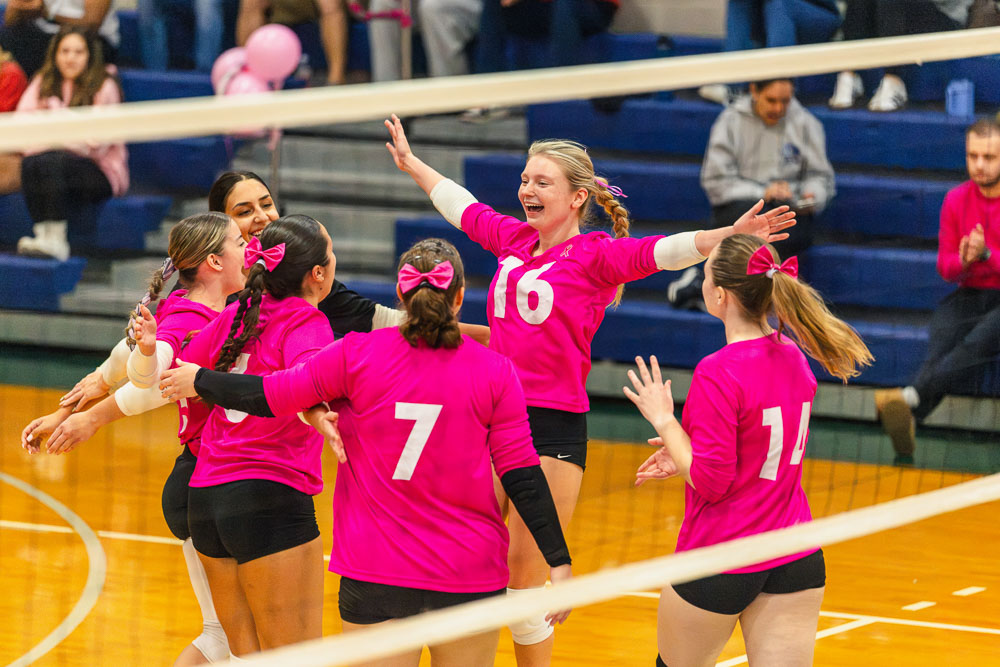 Women's volleyball celebrating during a game