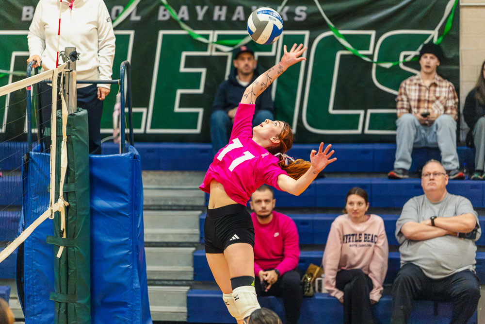 Woman leaping for a volleyball to return