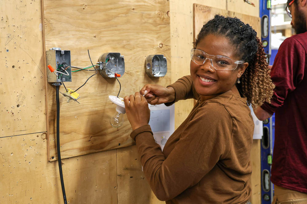 Bristol Community College HVAC student working with a lightbulb and electrical fixture