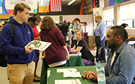 standing student at exhibit table